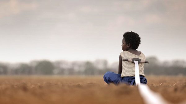 I Am Not a Witch film image; young girl sitting on the ground with a ribbon coming out of her back
