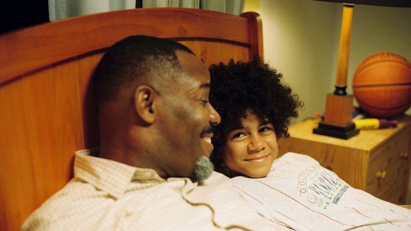 Pasa Faho film image; dad and his kid laughing in bed