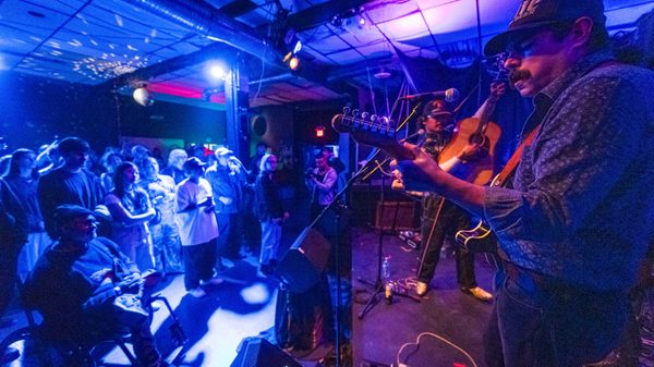 two people playing guitars onstage to a crowd