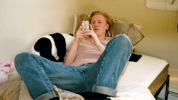 Castration film image; man on phone lying in bed