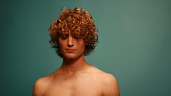 Heartbeats film image; person against a green wall