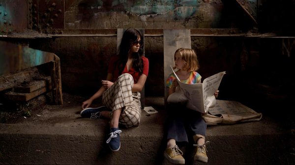 Monica's News film image; two girls sitting next to each other