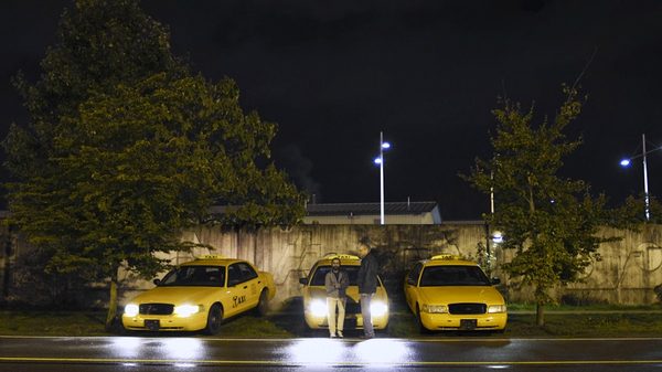 Cabbie film image; three taxis parked in a lot at night
