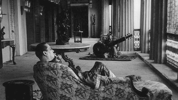The Music Room film image; man lounging in a chair in a decadent room