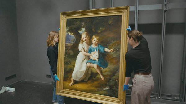 The Spoils film image; two people carrying a large framed painting