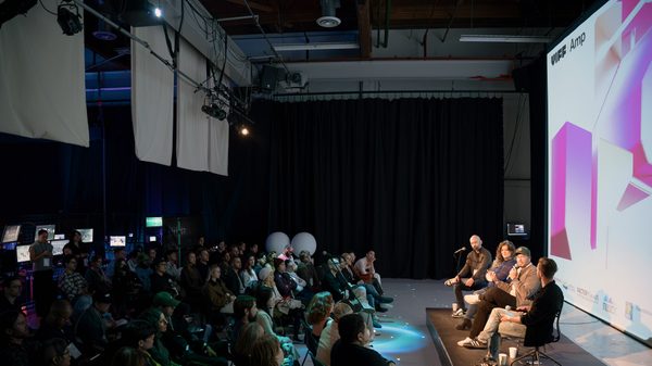 people in an audience watching a presentation on stage