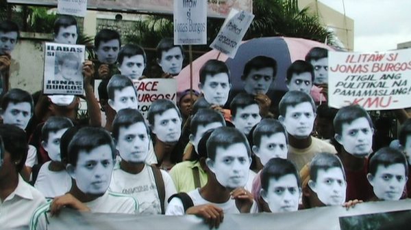 Alipato At Muog film image; group of people holding up cutouts of someone's face