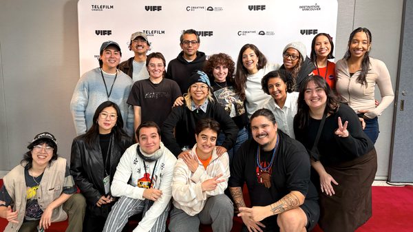 group posing in front of a step and repeat