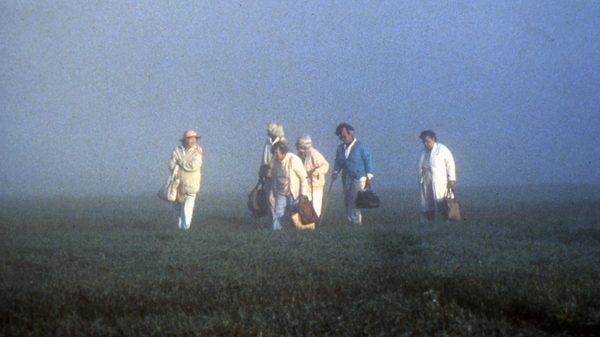 The Company of Strangers film image; people walking through a field