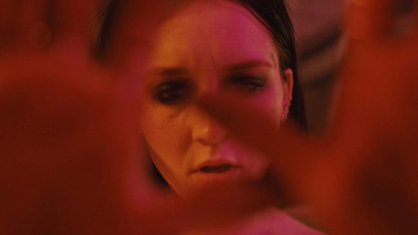 Lucid film image; woman holding her hands up towards the camera