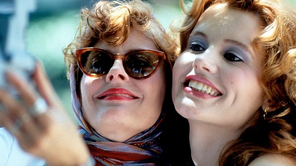 Thelma & Louise film image; two women pressing their cheeks together and grinning
