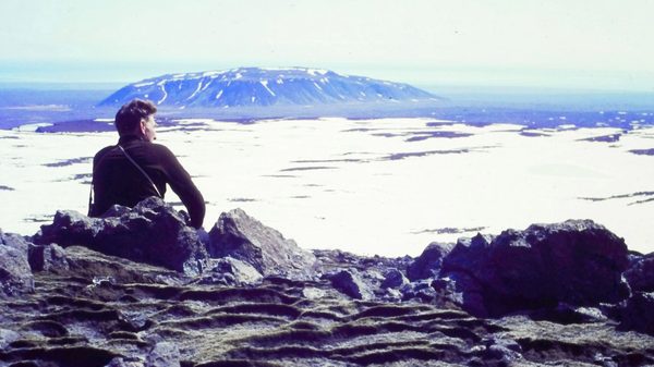 Time and Water film image; person sitting overlooking a snowy landscape