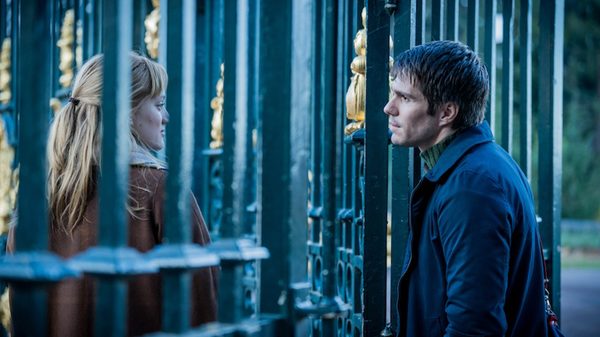 Two Pianos film image; two people looking at each other through a fence
