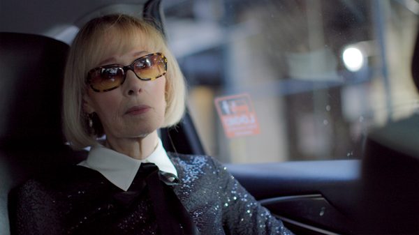 Ask E. Jean film image; woman sitting in the back of a car