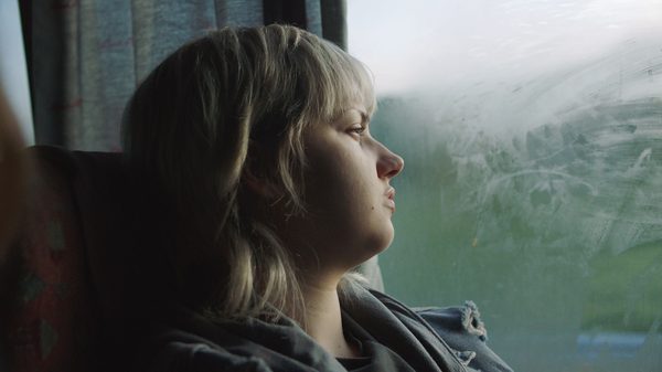 17 film image; girl looking out a window