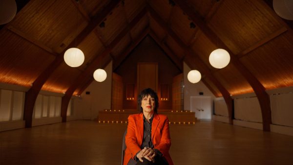 Antidiva film image; woman sitting in a large empty room