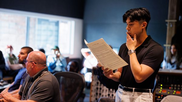 people in a sound-mixing room working on a music score
