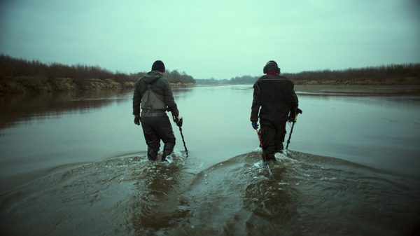 Closure film image; two people walking through water