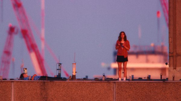 Everytime film image; woman standing on a roof