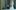 La Gradiva film image; man standing next to a large marble statue
