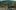 Whispers in May film image; children walking on pavement with a mountain in the distance