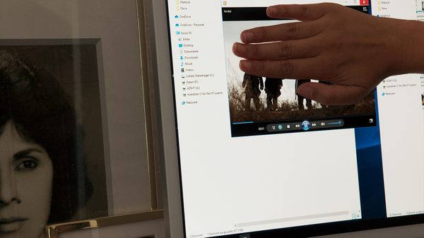 Afterlives film image; hand covering something on a computer screen