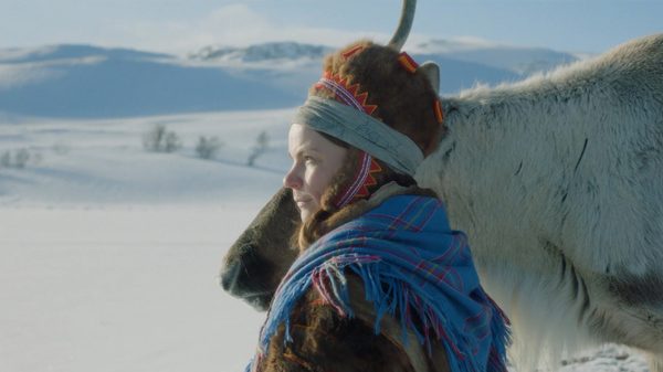 Árru film image; woman standing with a horse