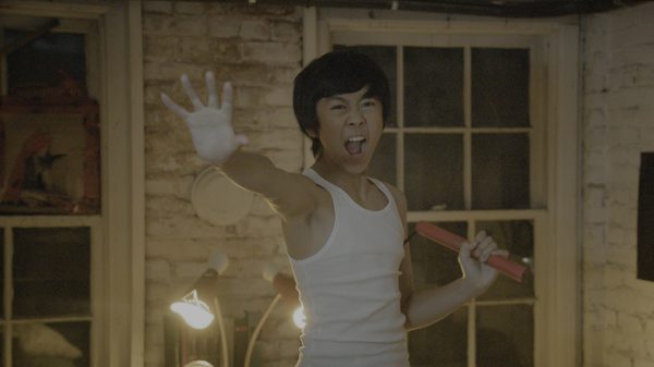 The Bryce Lee Story film image; boy holding his hand out in stop gesture and yelling