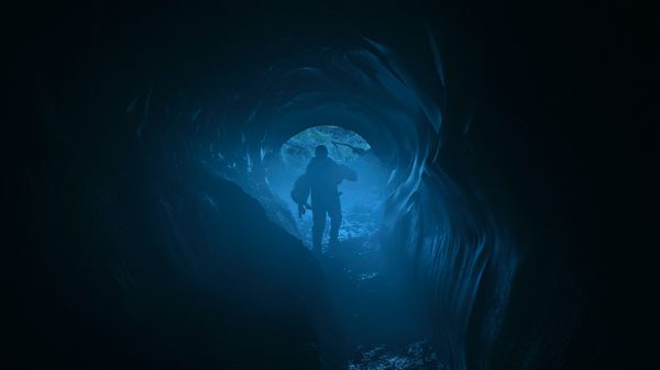 Chuuraa film image; silhouette of a person walking into a small cave entrance
