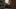 Clubfoot film image; three people at the end of an aisle in a library