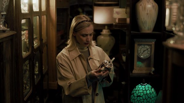 Collectors film image; woman examining an ornate teapot in her hands