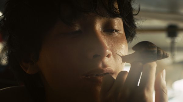 The Dream Is a Snail film image; boy looking at large snail on his fingertips
