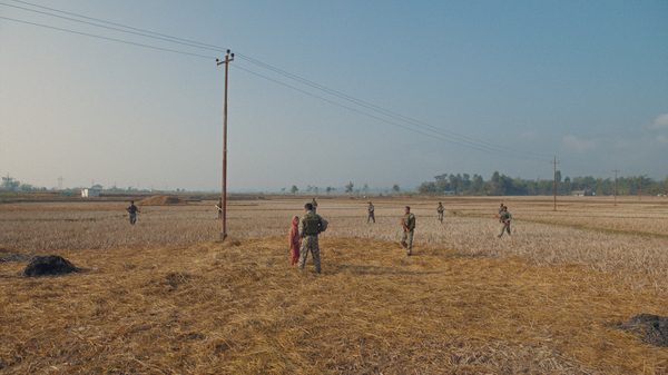 Fireflies in the Dark film image; soldiers with guns approaching a young boy