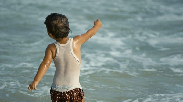 Free Fish film image; boy running to the ocean