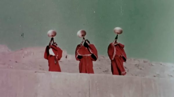 Ghazal-E Sorkh film image; three people in robes blowing into horns
