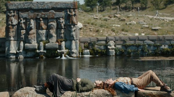 Hear the Yellow film image; two people lying by a river