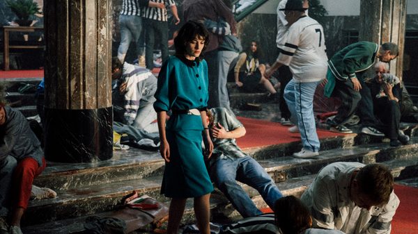 Heysel 85 film image; woman walking past crowd of injured people