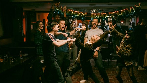 I See Buildings Fall Like Lightning film image; group of men celebrating in a bar