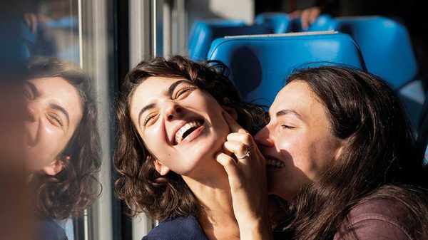 Idda film image; two women laughing on a bus