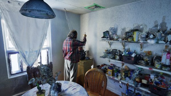 Jabber film image; man standing in the corner of a room