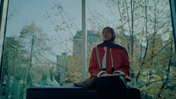 Lifeline film image; person with a book on their lap sitting by a window