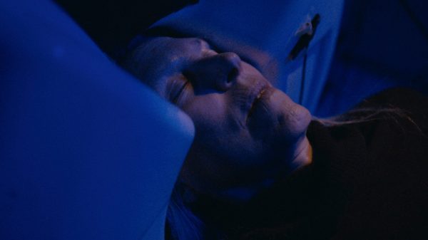 Like Moths to Light film image; woman lying in bed