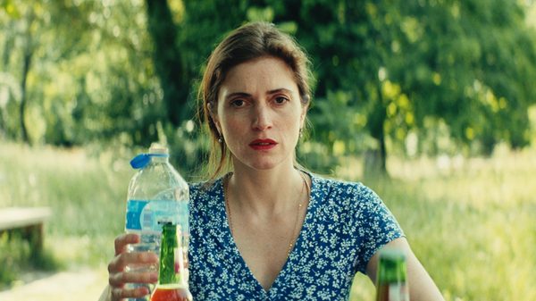 Lippenstift film image; woman holding a plastic bottle