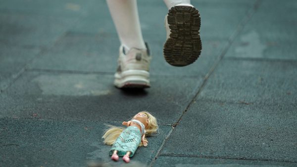 These Voices Are Real film image; feet walking past a doll on the ground