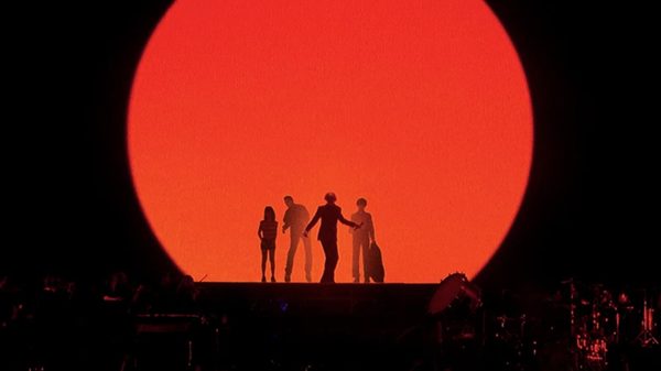 PULP film image; silhouettes of people in front of a red circle of light