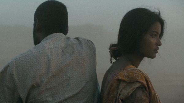 Roid film image; two people sitting with their backs to each other