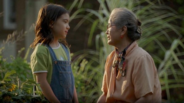 Send the Rain film image; young girl talking to an older woman outside