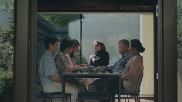 Sitting Bird film image; people sitting around a table