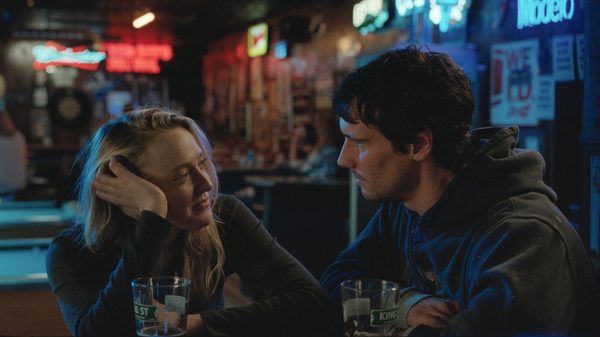 The Sun Never Sets film image; woman looking at man at bar counter