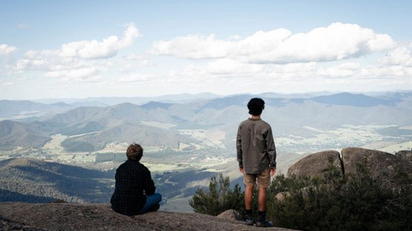 Sweet Milk Lake film image; two people overlooking a valley